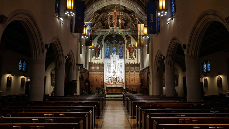 Church interior with wooden pews and stained glass windows