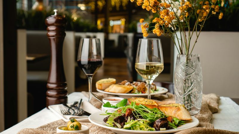 Restaurant table with plated food and wine
