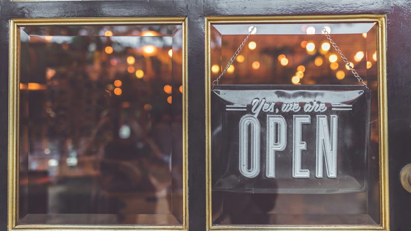 “Yes, we are open” sign on a shop door